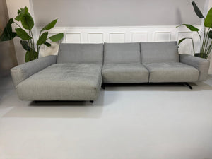 Gebrauchtes graues Rolf Benz 50 Designer Stoff Sofa vor einer Wand, stilvoll und modern eingerichtet.