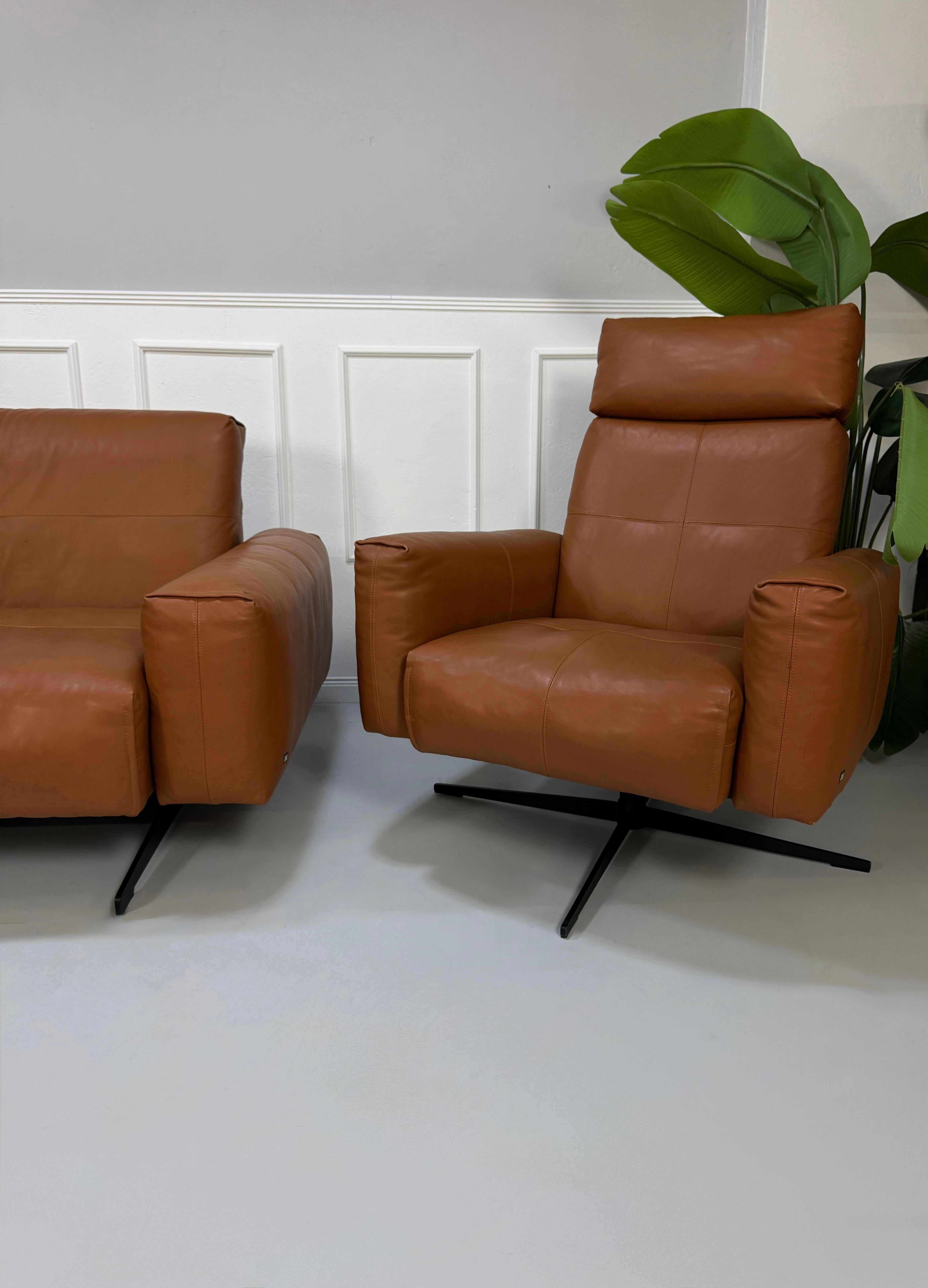 Gebrauchte braune Rolf Benz Leder 50 Designer Leder Garnitur vor einer Wand, stilvoll und modern eingerichtet.