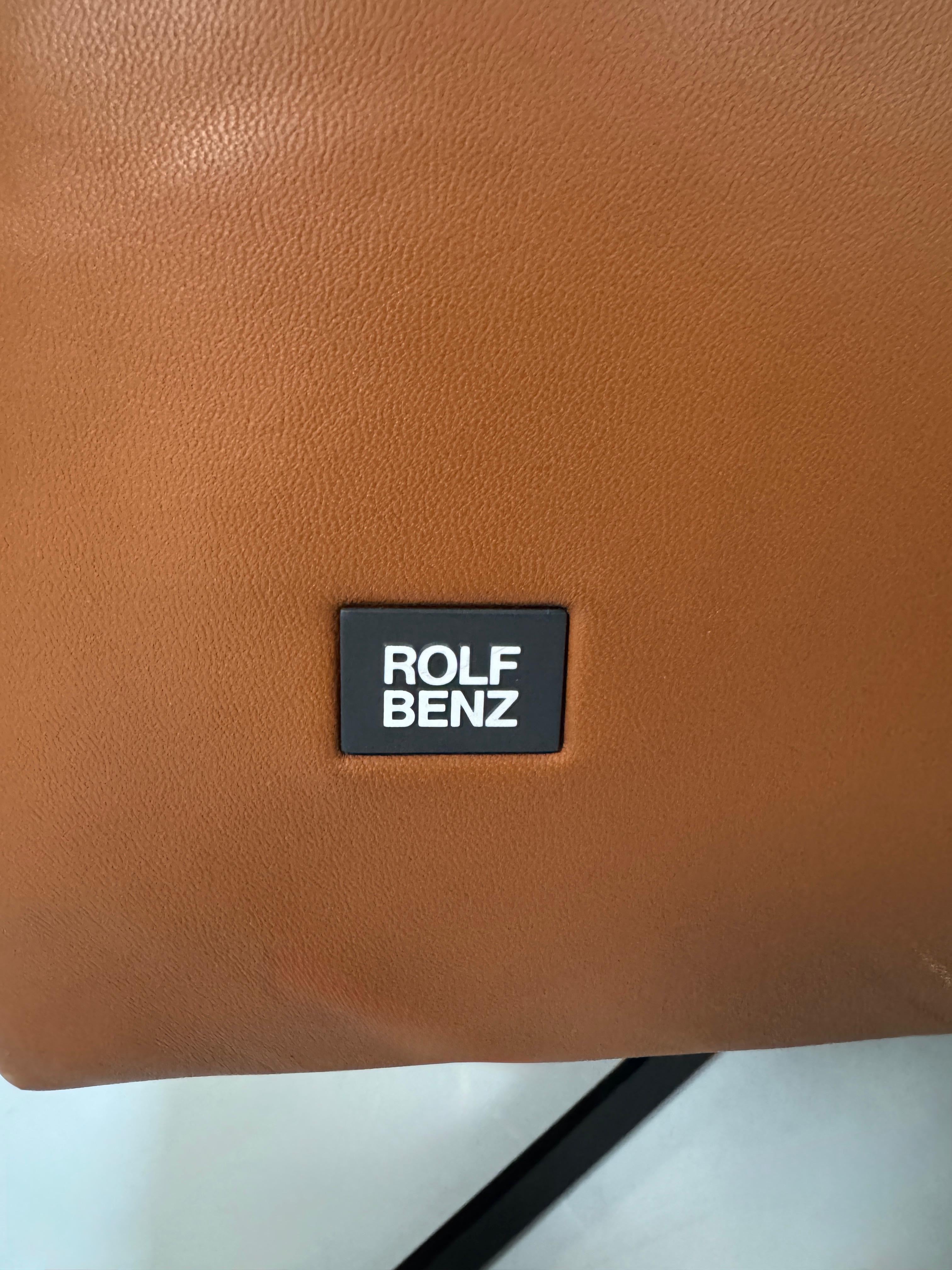 Gebrauchte braune Rolf Benz Leder 50 Designer Leder Garnitur vor einer Wand, stilvoll und modern eingerichtet.