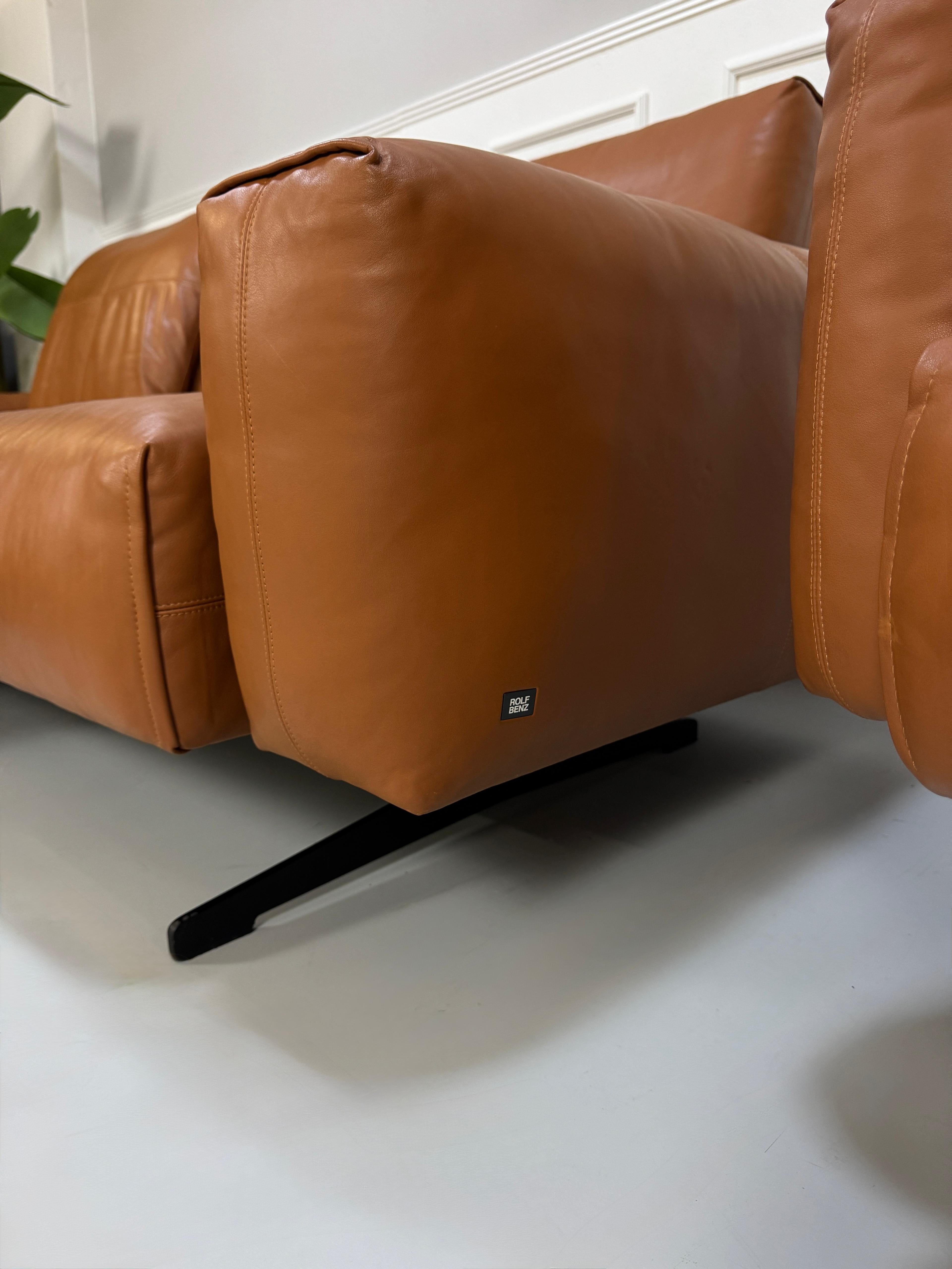 Gebrauchte braune Rolf Benz Leder 50 Designer Leder Garnitur vor einer Wand, stilvoll und modern eingerichtet.