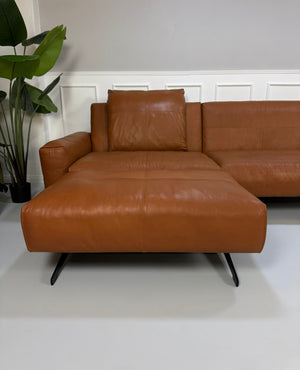 Gebrauchte braune Rolf Benz Leder 50 Designer Leder Garnitur vor einer Wand, stilvoll und modern eingerichtet.