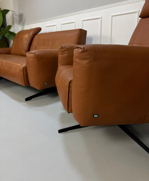 Gebrauchte braune Rolf Benz Leder 50 Designer Leder Garnitur vor einer Wand, stilvoll und modern eingerichtet.