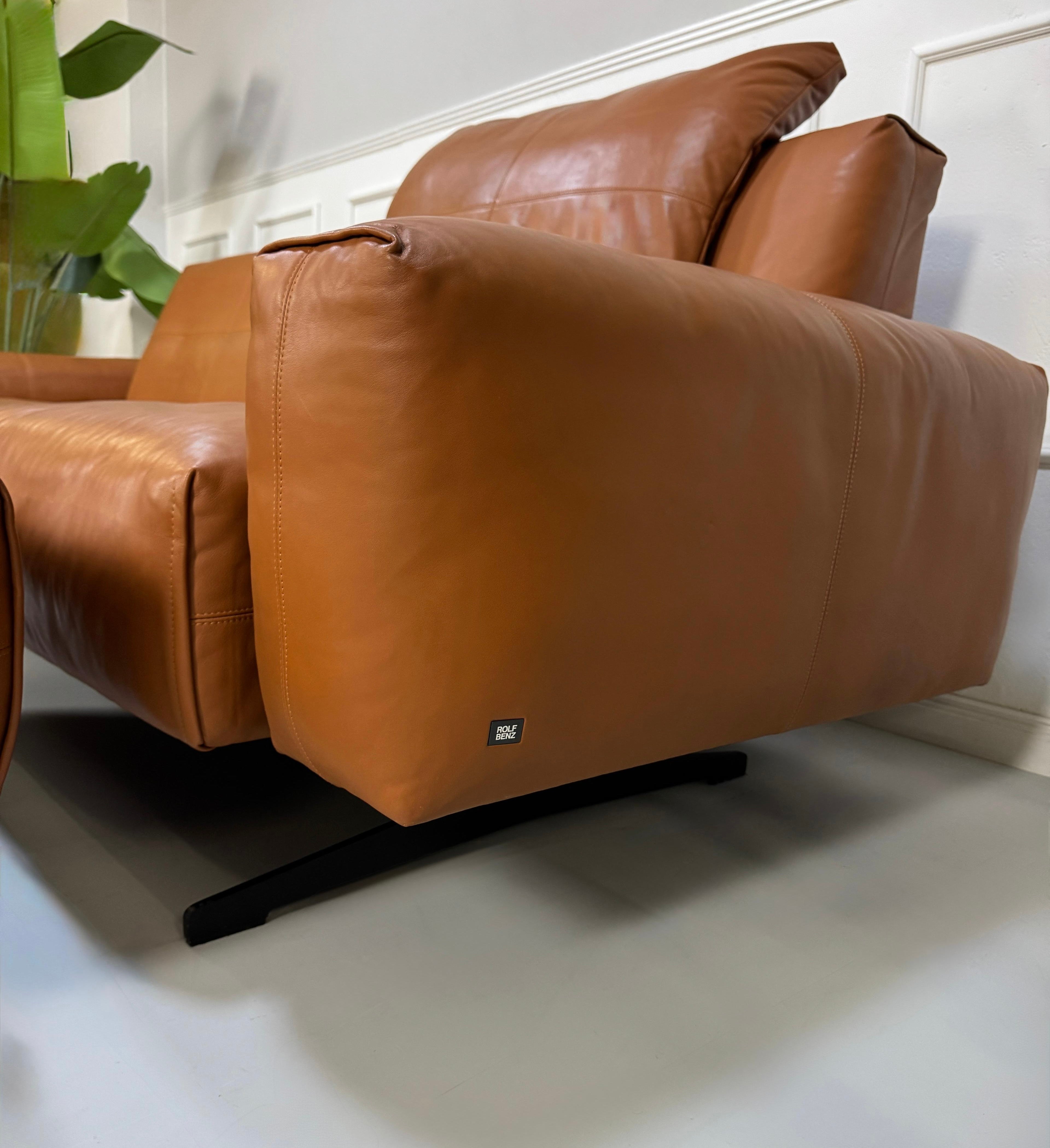Gebrauchte braune Rolf Benz Leder 50 Designer Leder Garnitur vor einer Wand, stilvoll und modern eingerichtet.