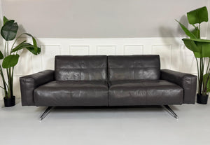 Refurbished graues Rolf Benz 50  Designer Leder Sofa vor einer Wand, stilvoll und modern eingerichtet.