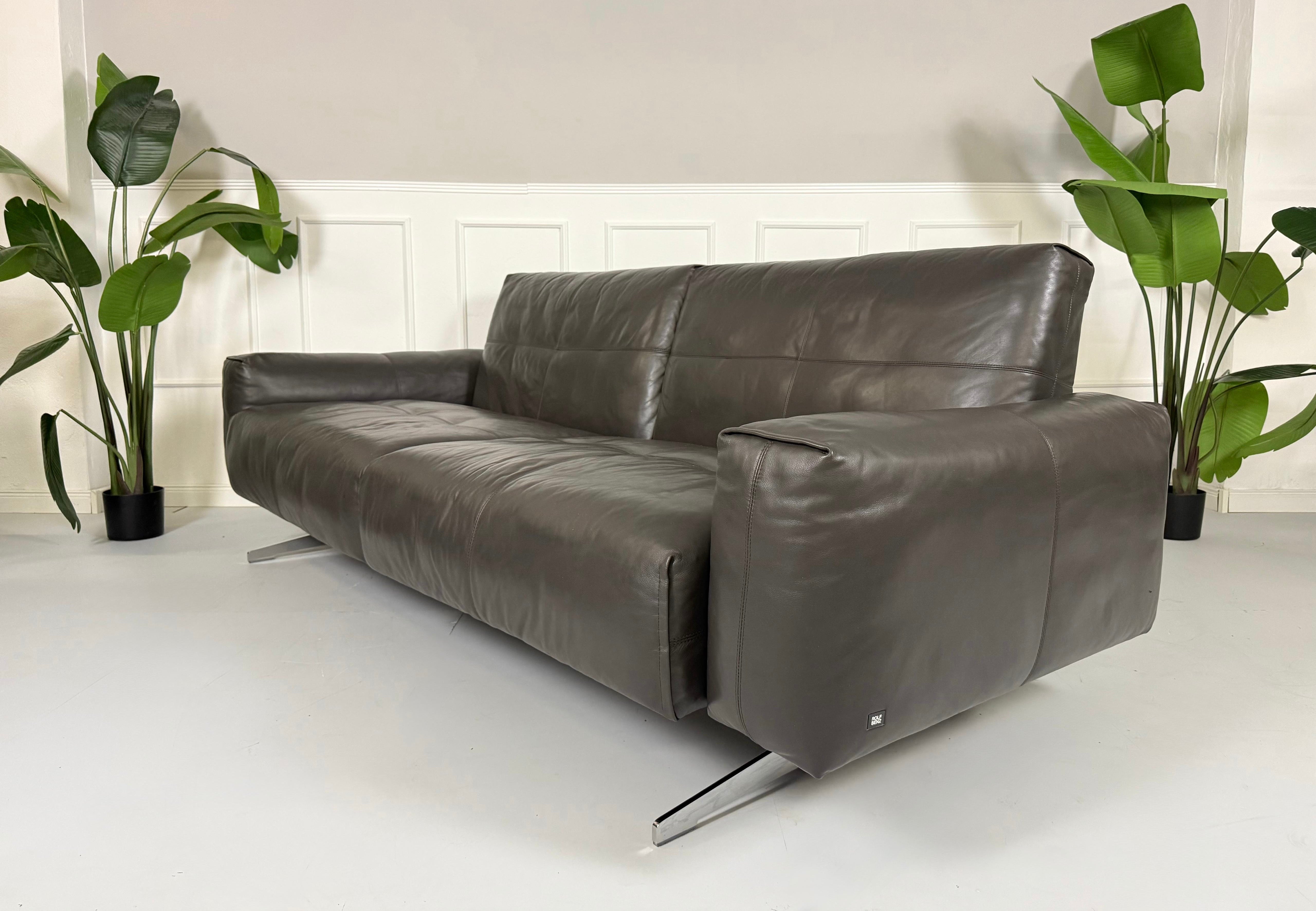 Refurbished graues Rolf Benz 50  Designer Leder Sofa vor einer Wand, stilvoll und modern eingerichtet.