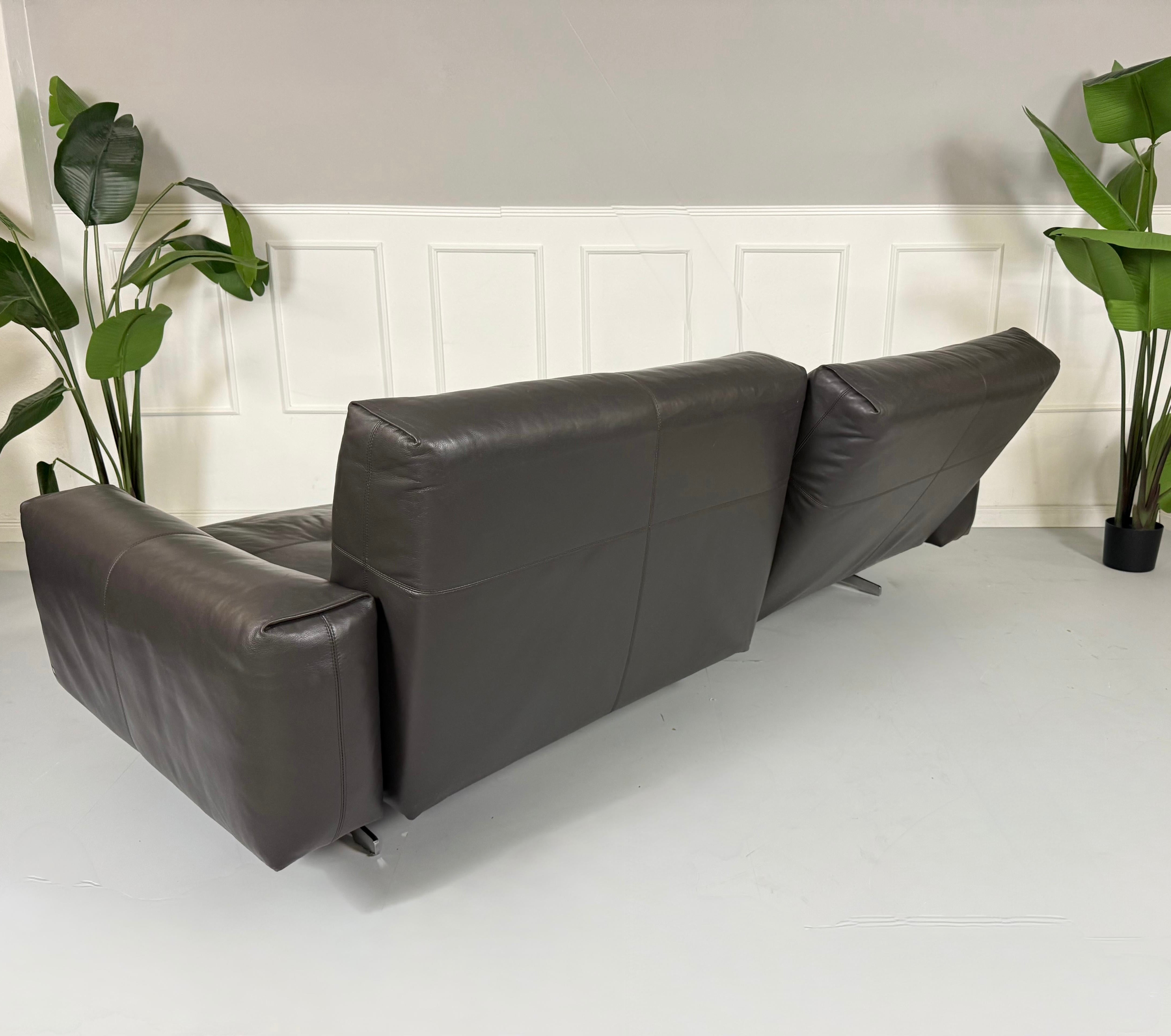 Refurbished graues Rolf Benz 50  Designer Leder Sofa vor einer Wand, stilvoll und modern eingerichtet.