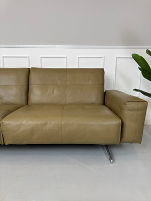 Erneuertes Rolf Benz 50 mit Hocker  Designer Leder Sofa vor einer Wand, stilvoll und modern eingerichtet.