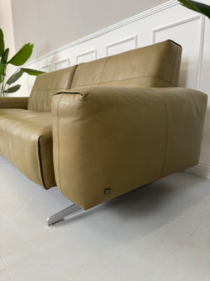Erneuertes Rolf Benz 50 mit Hocker  Designer Leder Sofa vor einer Wand, stilvoll und modern eingerichtet.