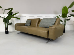 Erneuertes Rolf Benz 50 mit Hocker  Designer Leder Sofa vor einer Wand, stilvoll und modern eingerichtet.