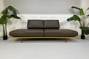 Gebrauchtes braunes Rolf Benz Aura Designer Leder Sofa vor einer Wand, stilvoll und modern eingerichtet.