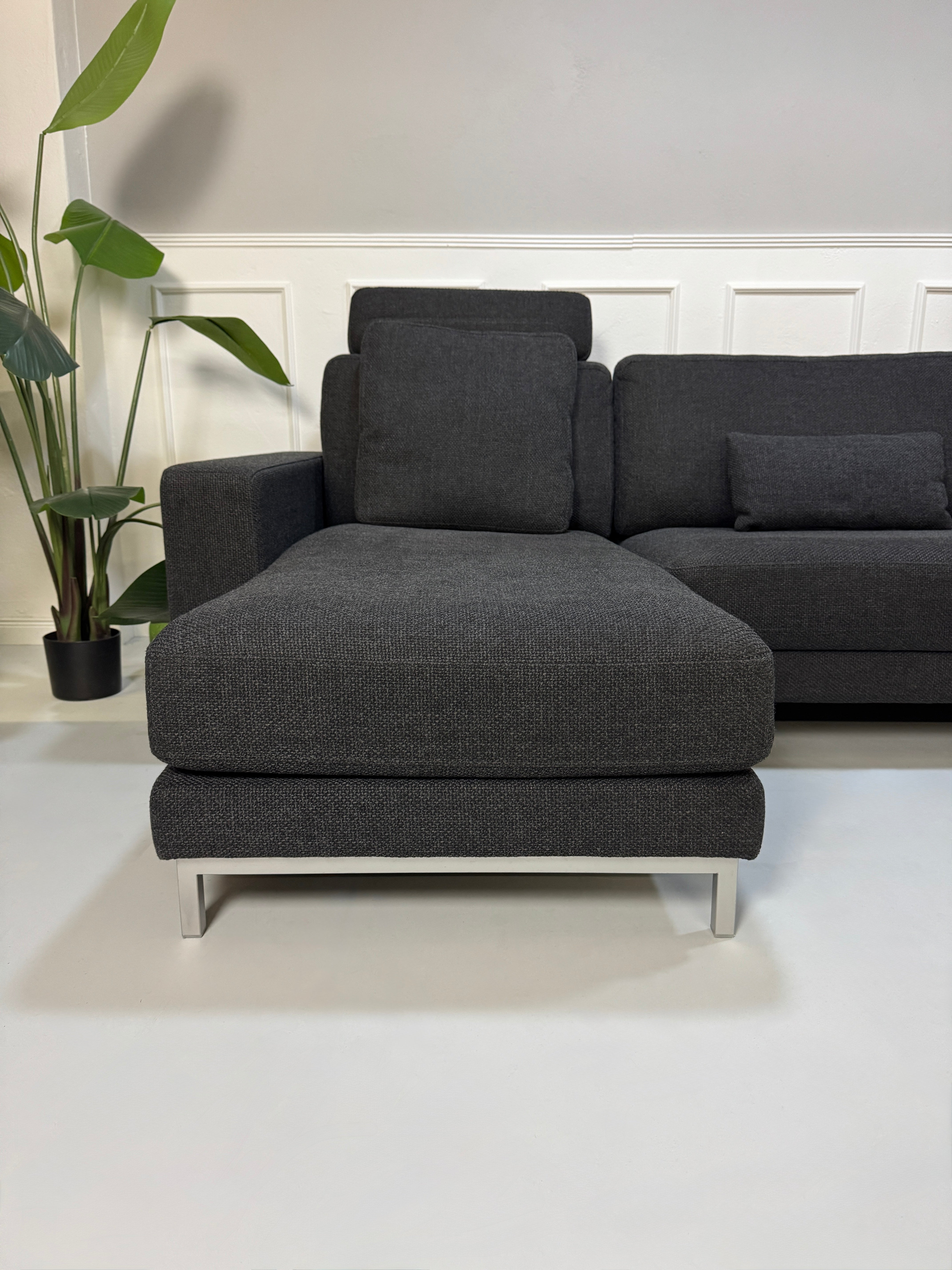 Rolf Benz Sofa Ego in der Farbe Grau Designer Stoff Sofa vor einer Wand, stilvoll und modern eingerichtet.