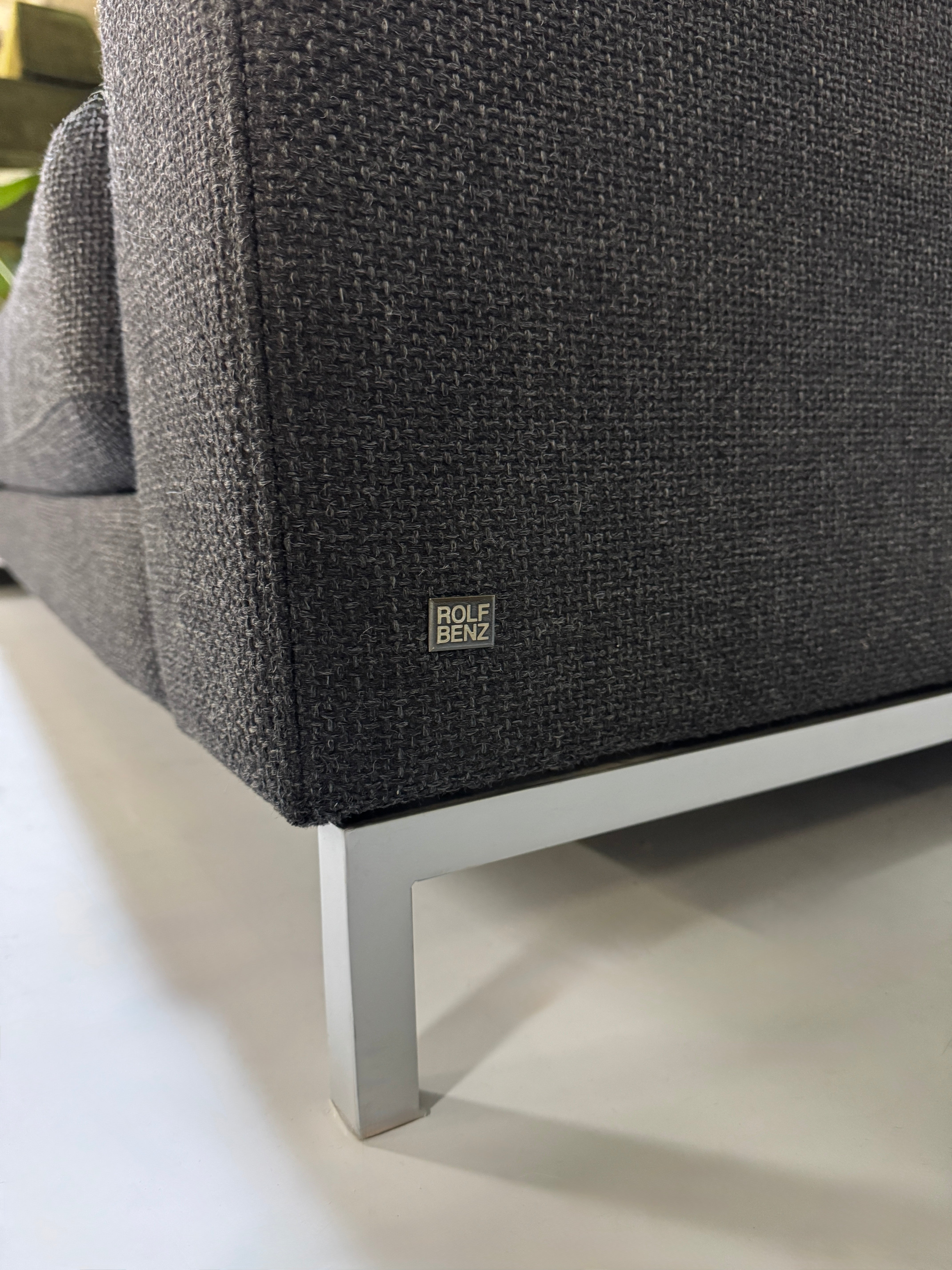 Rolf Benz Sofa Ego in der Farbe Grau Designer Stoff Sofa vor einer Wand, stilvoll und modern eingerichtet.