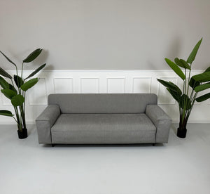 Gebrauchtes graues Rolf Benz Grata Designer Stoff Sofa vor einer Wand, stilvoll und modern eingerichtet.