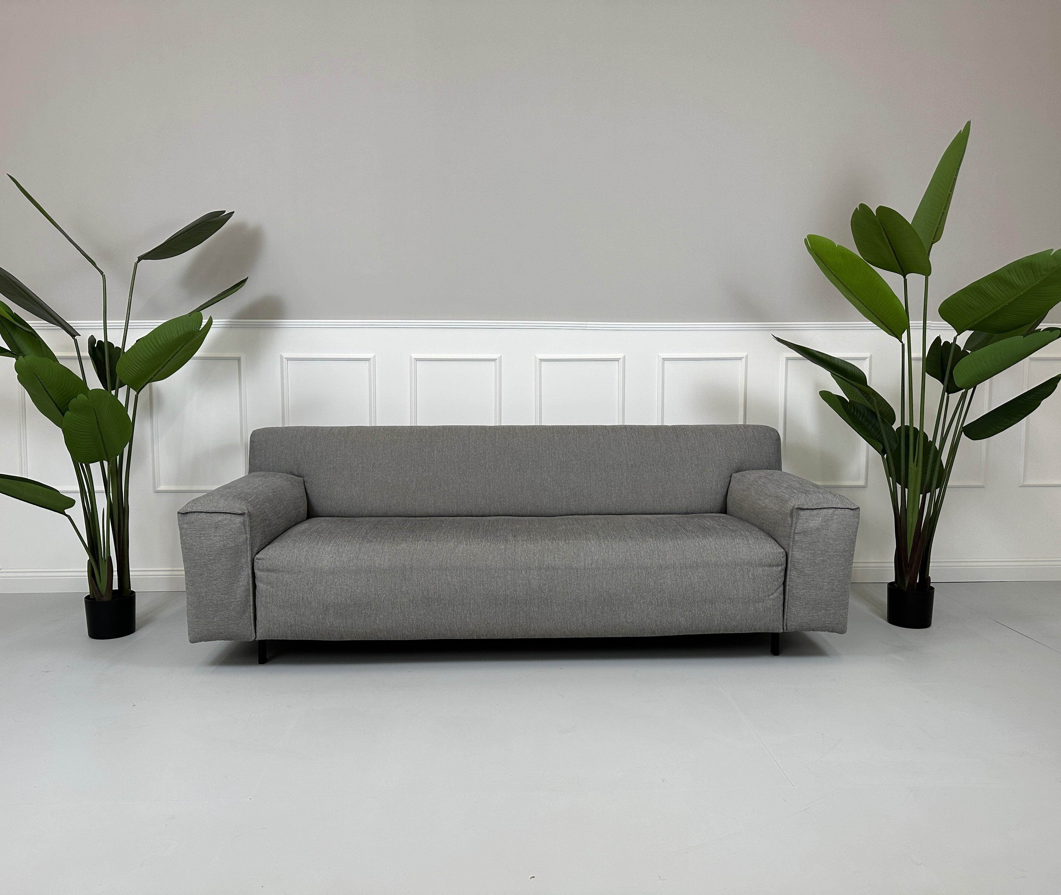 Gebrauchtes graues Rolf Benz Grata Designer Stoff Sofa vor einer Wand, stilvoll und modern eingerichtet.