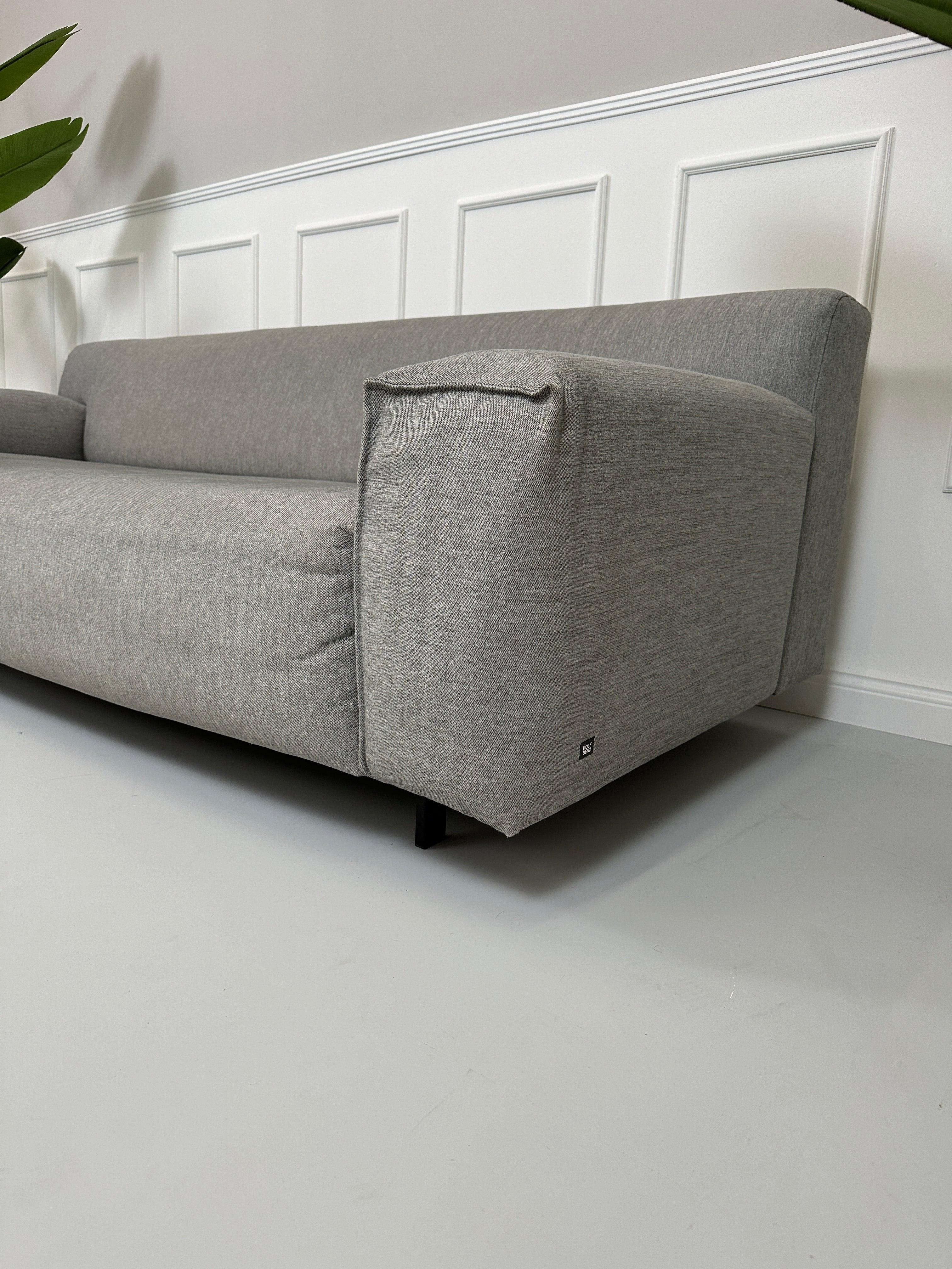 Gebrauchtes graues Rolf Benz Grata Designer Stoff Sofa vor einer Wand, stilvoll und modern eingerichtet.