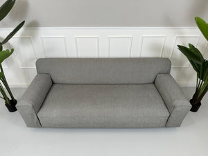 Gebrauchtes graues Rolf Benz Grata Designer Stoff Sofa vor einer Wand, stilvoll und modern eingerichtet.