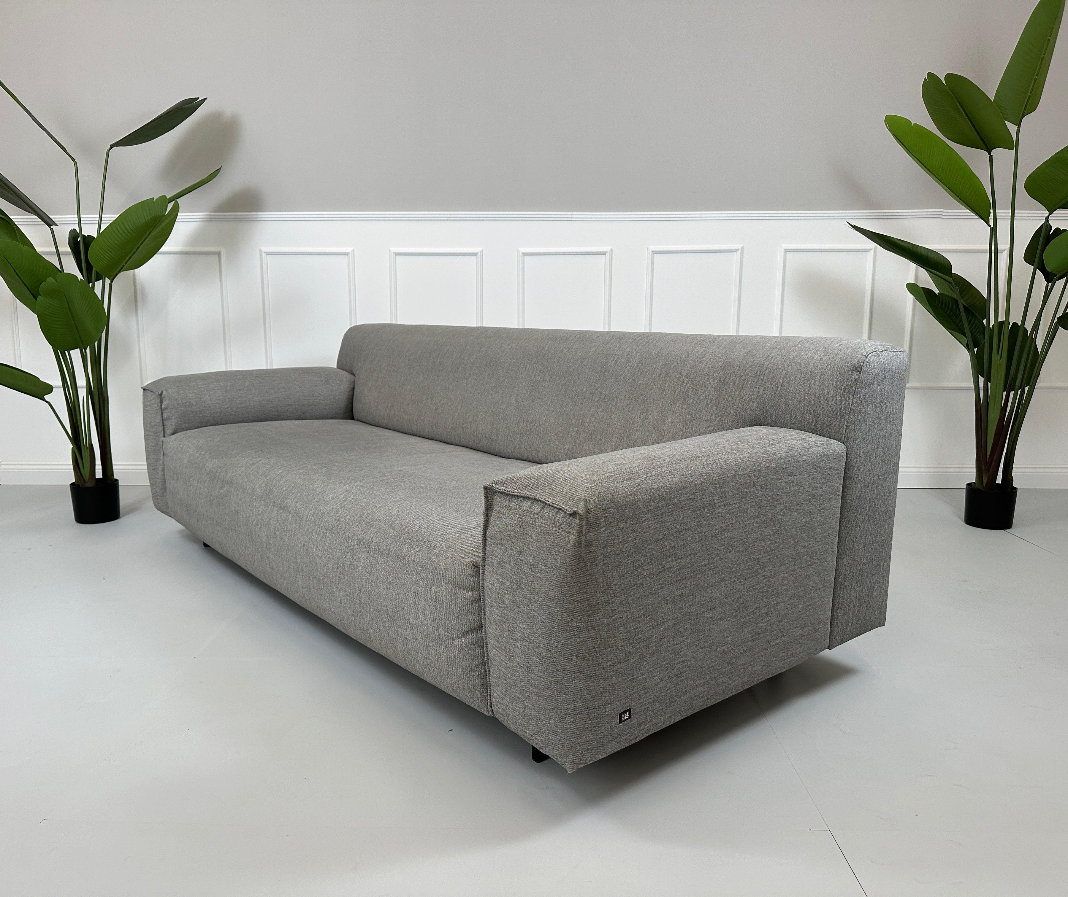 Gebrauchtes graues Rolf Benz Grata Designer Stoff Sofa vor einer Wand, stilvoll und modern eingerichtet.