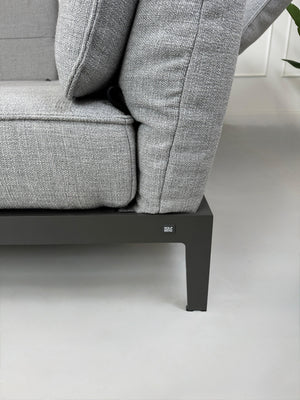 Graues Ausstellungsstück Rolf Benz Mera Designer Stoff Sofa vor einer Wand, stilvoll und modern eingerichtet.