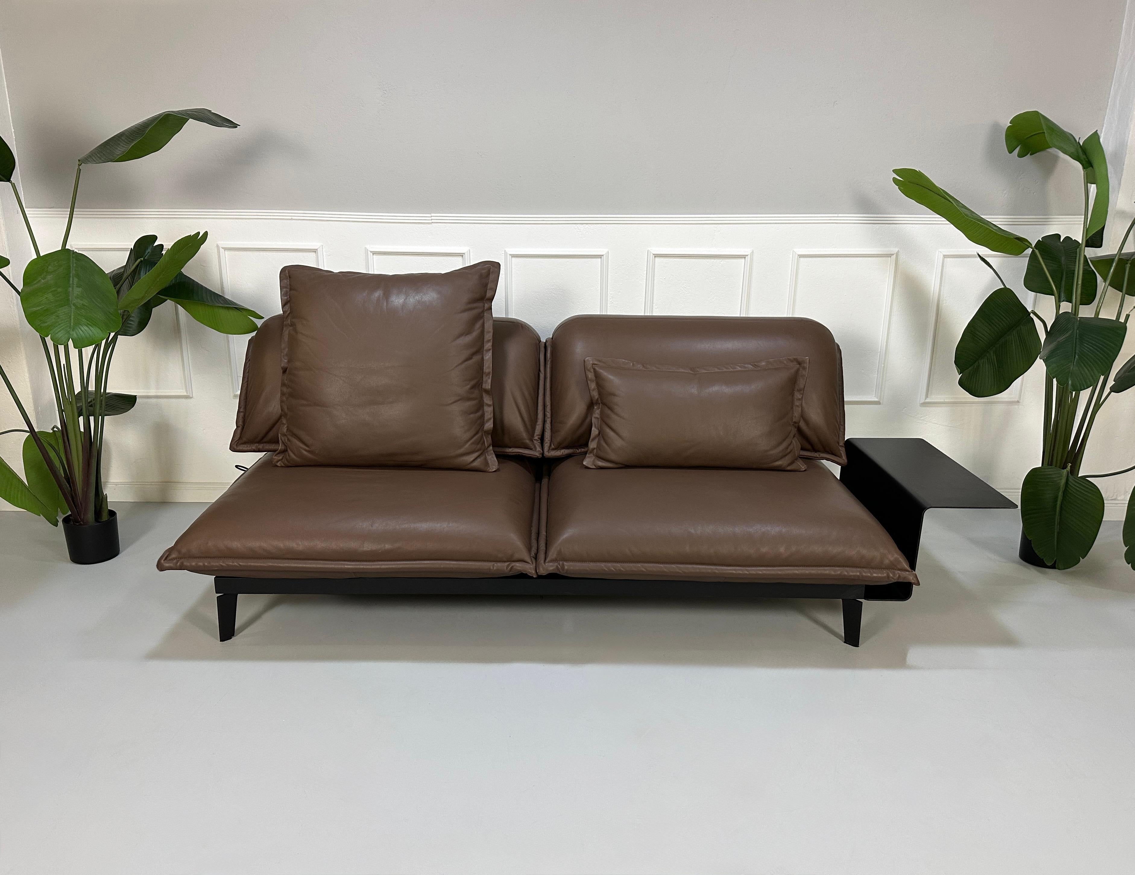 Gebrauchtes braunes Rolf Benz Nova Designer Leder Sofa vor einer Wand, stilvoll und modern eingerichtet.