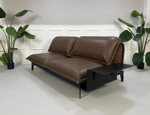Gebrauchtes braunes Rolf Benz Nova Designer Leder Sofa vor einer Wand, stilvoll und modern eingerichtet.