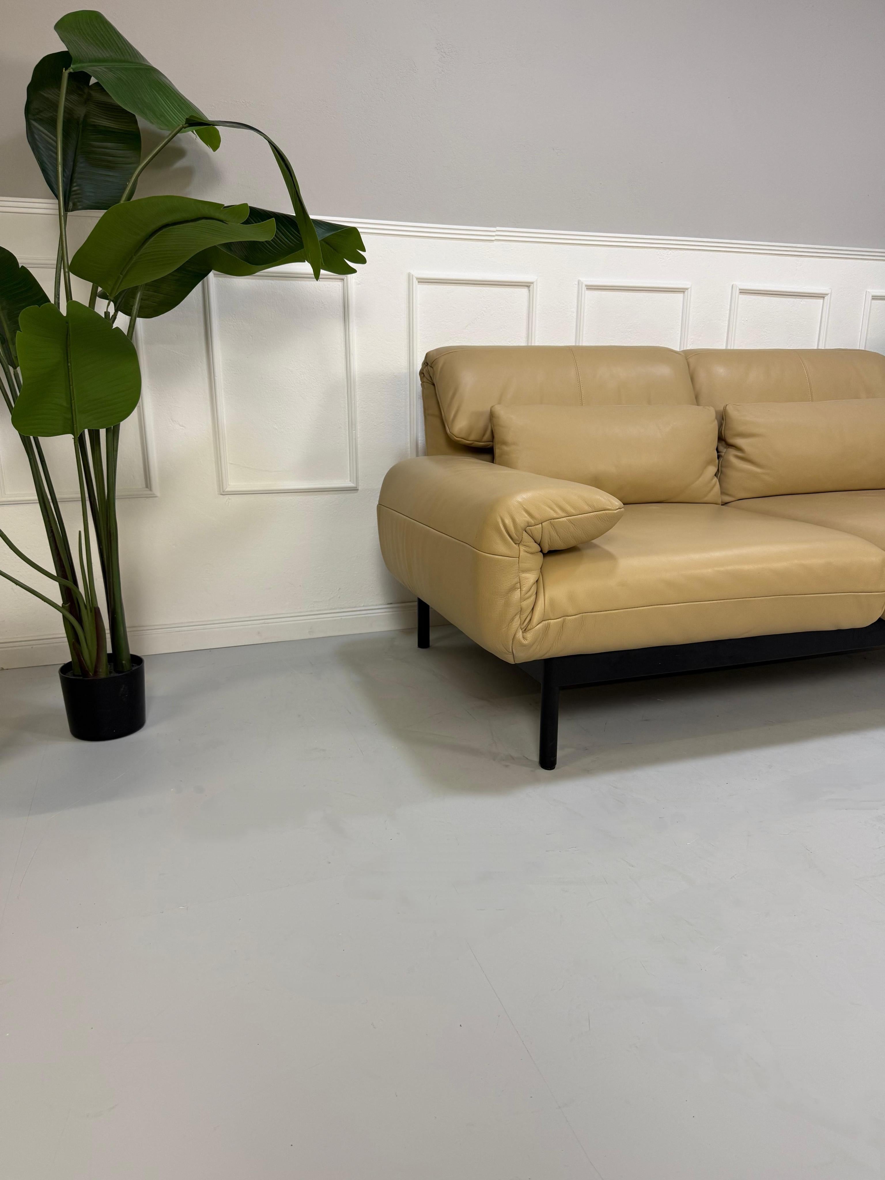 Gebrauchtes beiges Rolf Benz Plura Designer Leder Sofa vor einer Wand, stilvoll und modern eingerichtet.