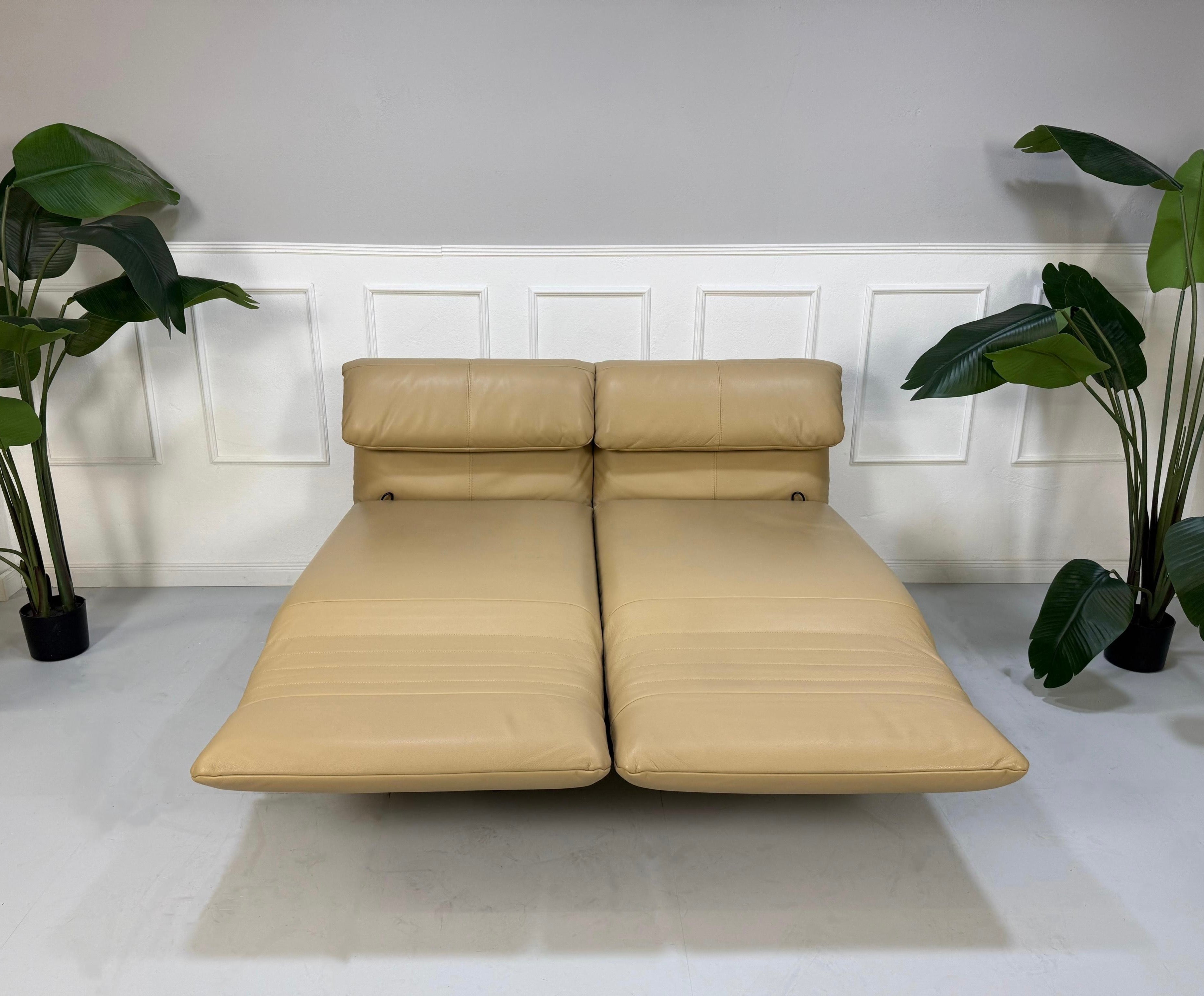 Gebrauchtes beiges Rolf Benz Plura Designer Leder Sofa vor einer Wand, stilvoll und modern eingerichtet.