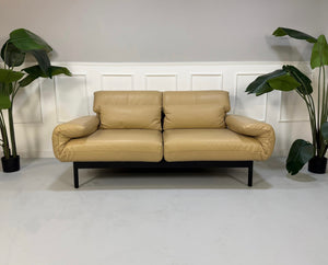 Gebrauchtes beiges Rolf Benz Plura Designer Leder Sofa vor einer Wand, stilvoll und modern eingerichtet.
