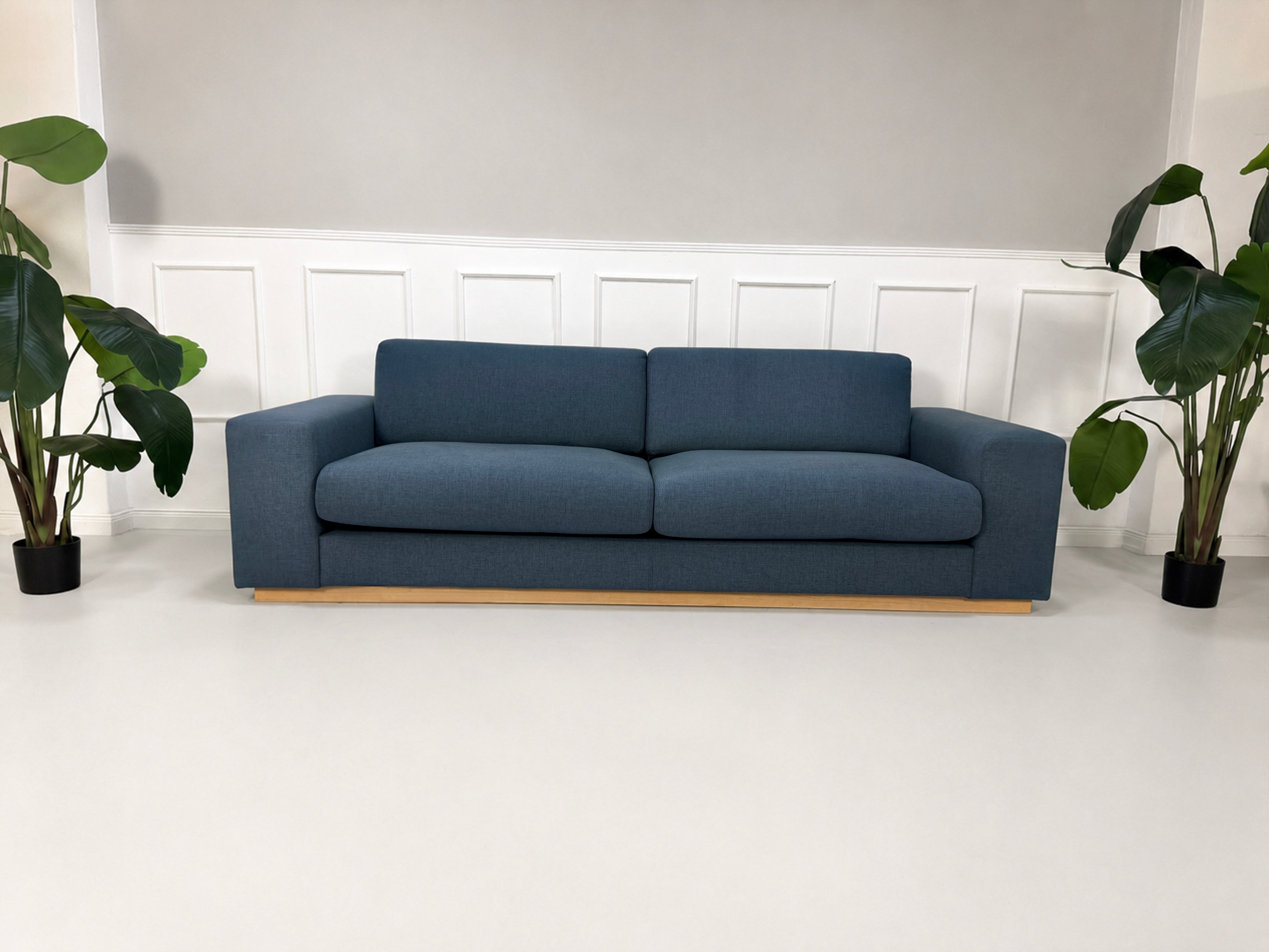 Gebrauchtes blaues Bolia Sepia Designer Stoff Sofa vor einer Wand, stilvoll und modern eingerichtet.