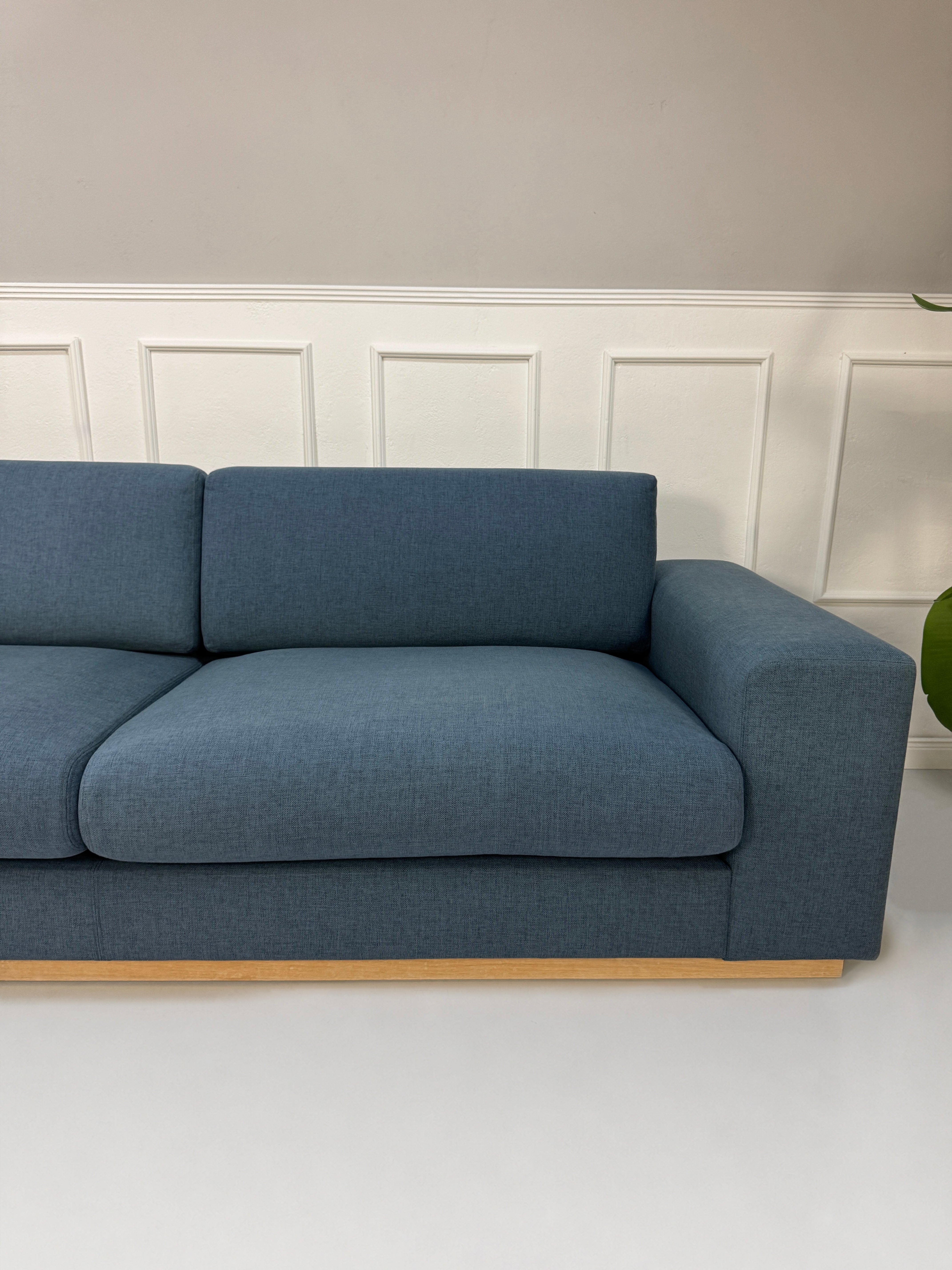 Gebrauchtes blaues Bolia Sepia Designer Stoff Sofa vor einer Wand, stilvoll und modern eingerichtet.