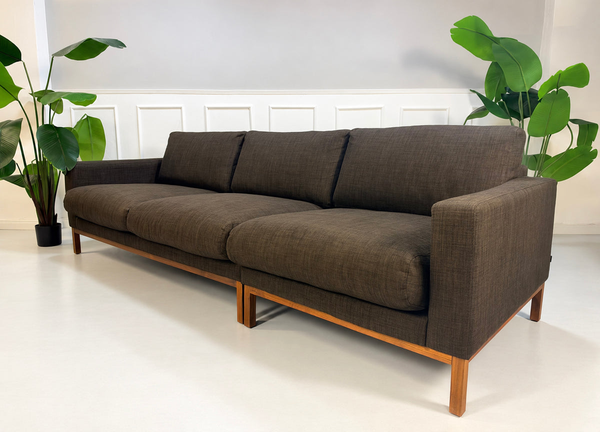 Gebrauchtes braunes Bolia North Designer Stoff Sofa vor einer Wand, stilvoll und modern eingerichtet.