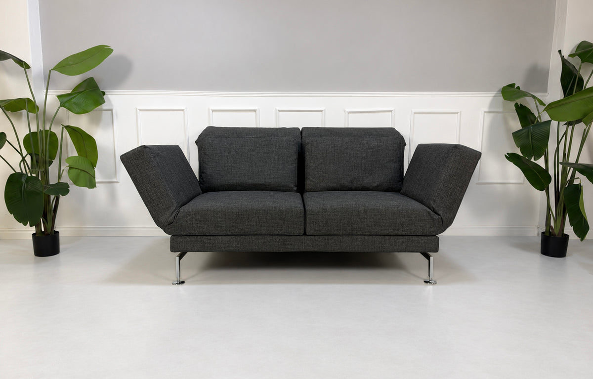 Gebrauchtes graues Brühl Moule Medium Designer Stoff Sofa vor einer Wand, stilvoll und modern eingerichtet.