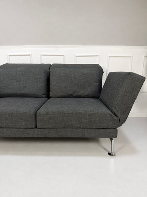 Gebrauchtes graues Brühl Moule Medium Designer Stoff Sofa vor einer Wand, stilvoll und modern eingerichtet.