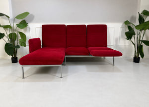 Gebrauchtes rotes Brühl Roro Medium Designer Stoff Ecksofa vor einer Wand, stilvoll und modern eingerichtet.