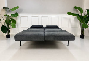Gebrauchtes graues Brühl Roro Soft Medium Designer Stoff Sofa vor einer Wand, stilvoll und modern eingerichtet.