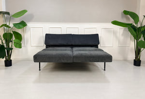 Gebrauchtes graues Brühl Roro Soft Medium Designer Stoff Sofa vor einer Wand, stilvoll und modern eingerichtet.