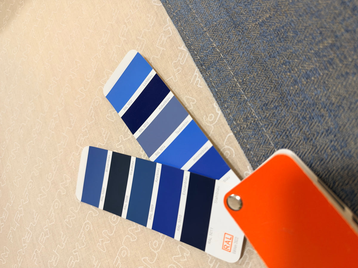 Gebrauchtes grau-blaues Flexform Lightpiece Designer Stoff Sofa vor einer Wand, stilvoll und modern eingerichtet.