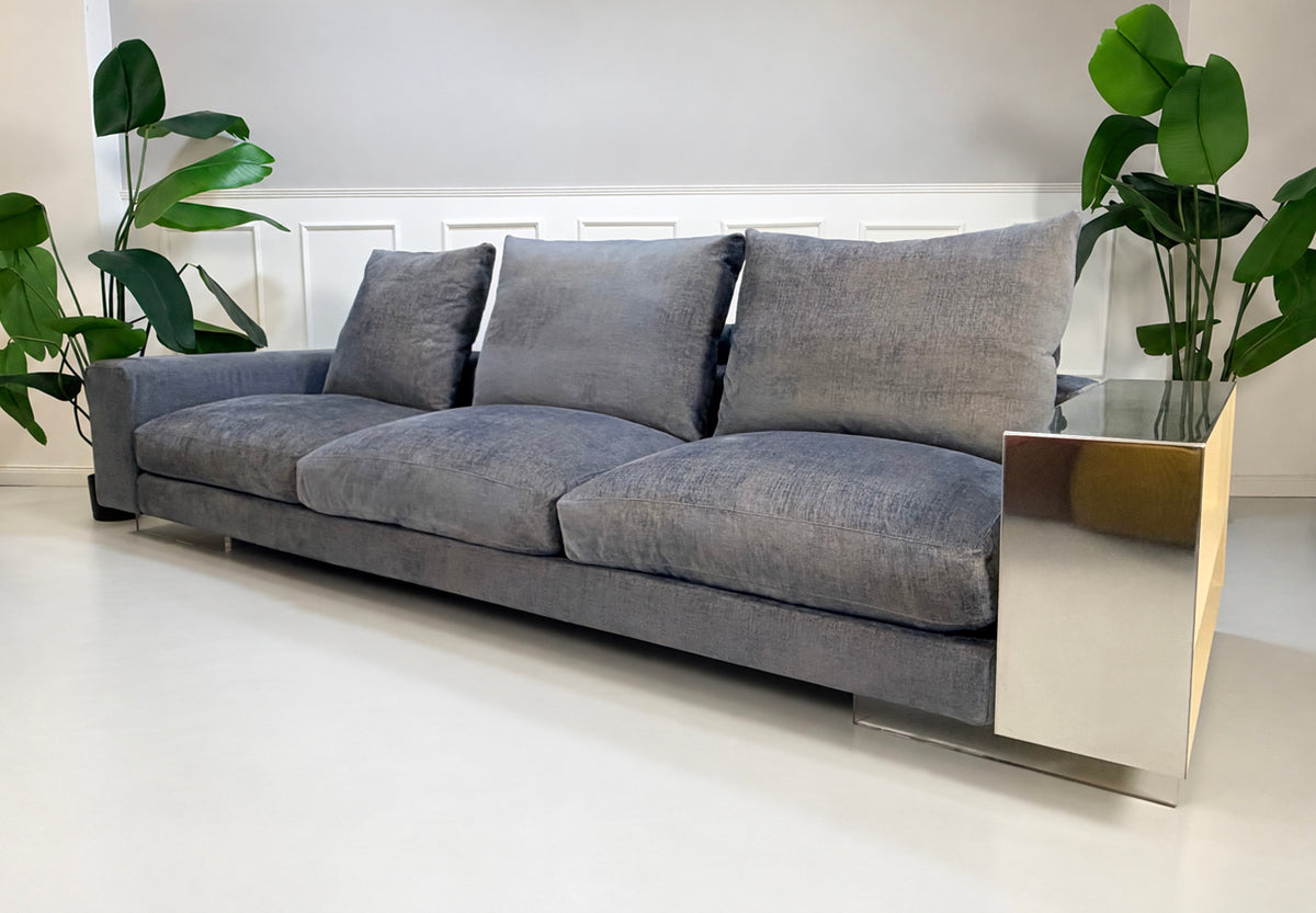 Gebrauchtes grau-blaues Flexform Lightpiece Designer Stoff Sofa vor einer Wand, stilvoll und modern eingerichtet.