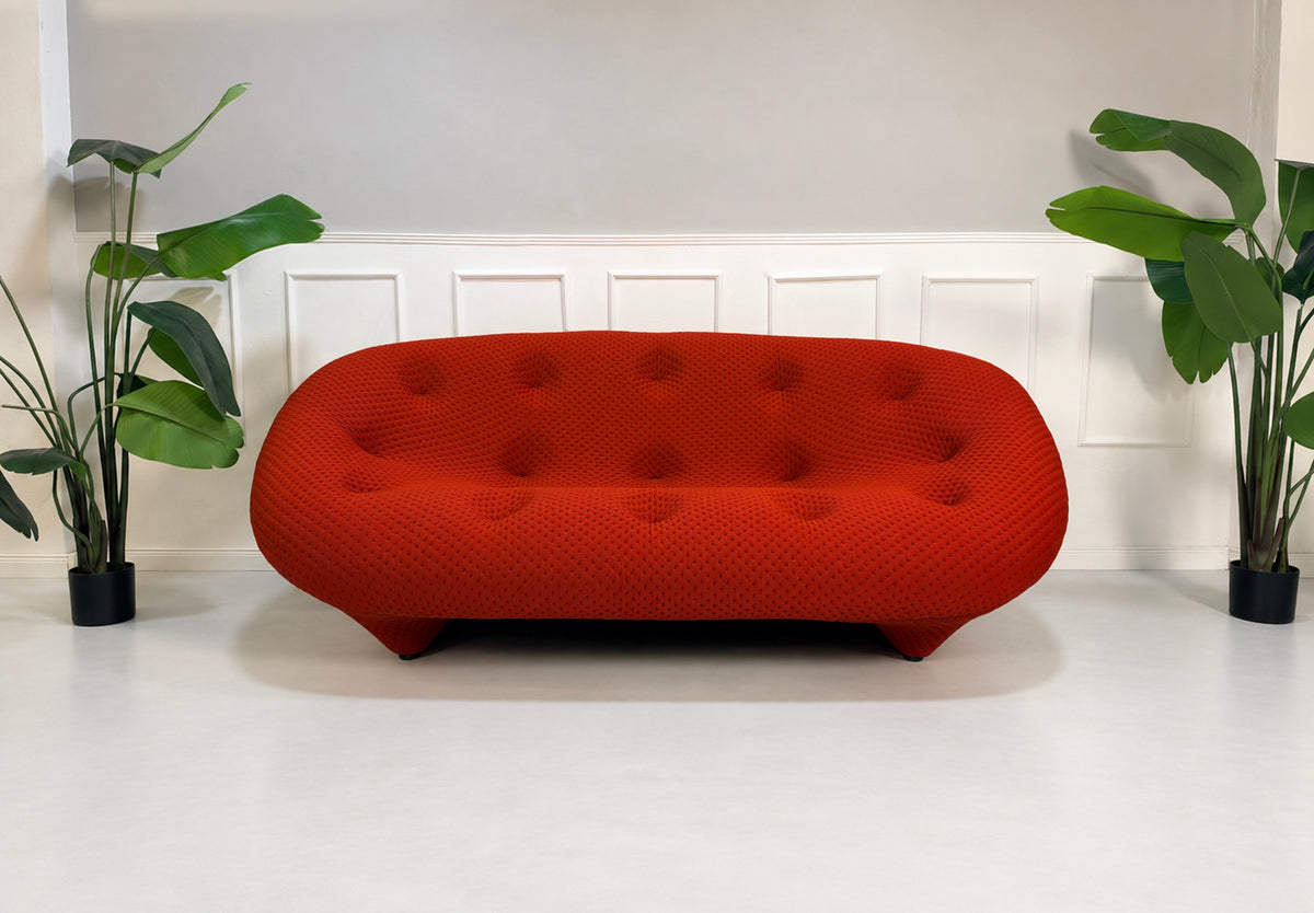 Gebrauchtes rotes Ligne Roset Ploum Designer Stoff Sofa vor einer Wand, stilvoll und modern eingerichtet.