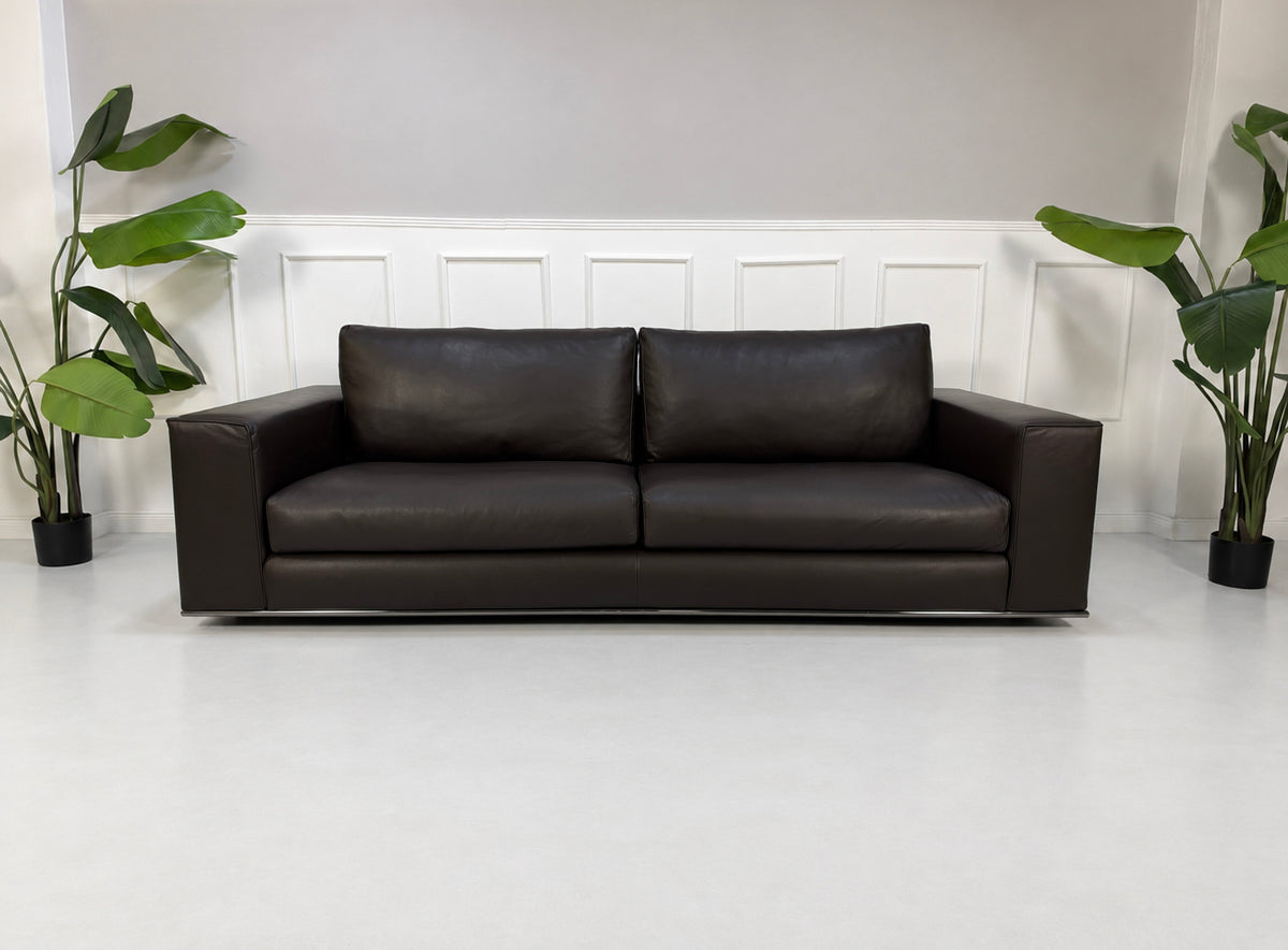 Gebrauchtes braunes Minotti Hamilton Designer Leder Sofa vor einer Wand, stilvoll und modern eingerichtet.
