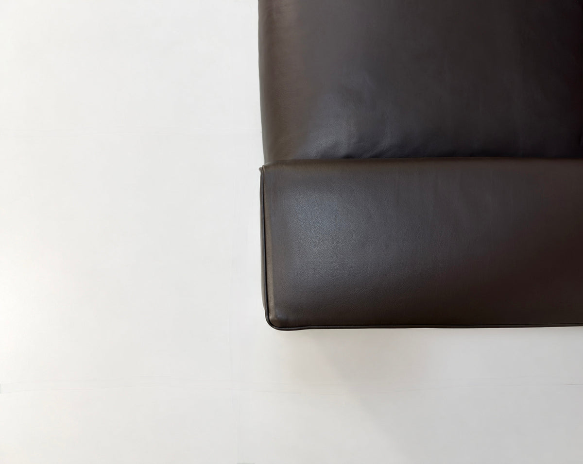 Gebrauchtes braunes Minotti Hamilton Designer Leder Sofa vor einer Wand, stilvoll und modern eingerichtet.