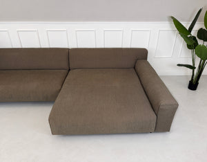Gebrauchtes braunes Rolf Benz Grata Designer Stoff Ecksofa vor einer Wand, stilvoll und modern eingerichtet.