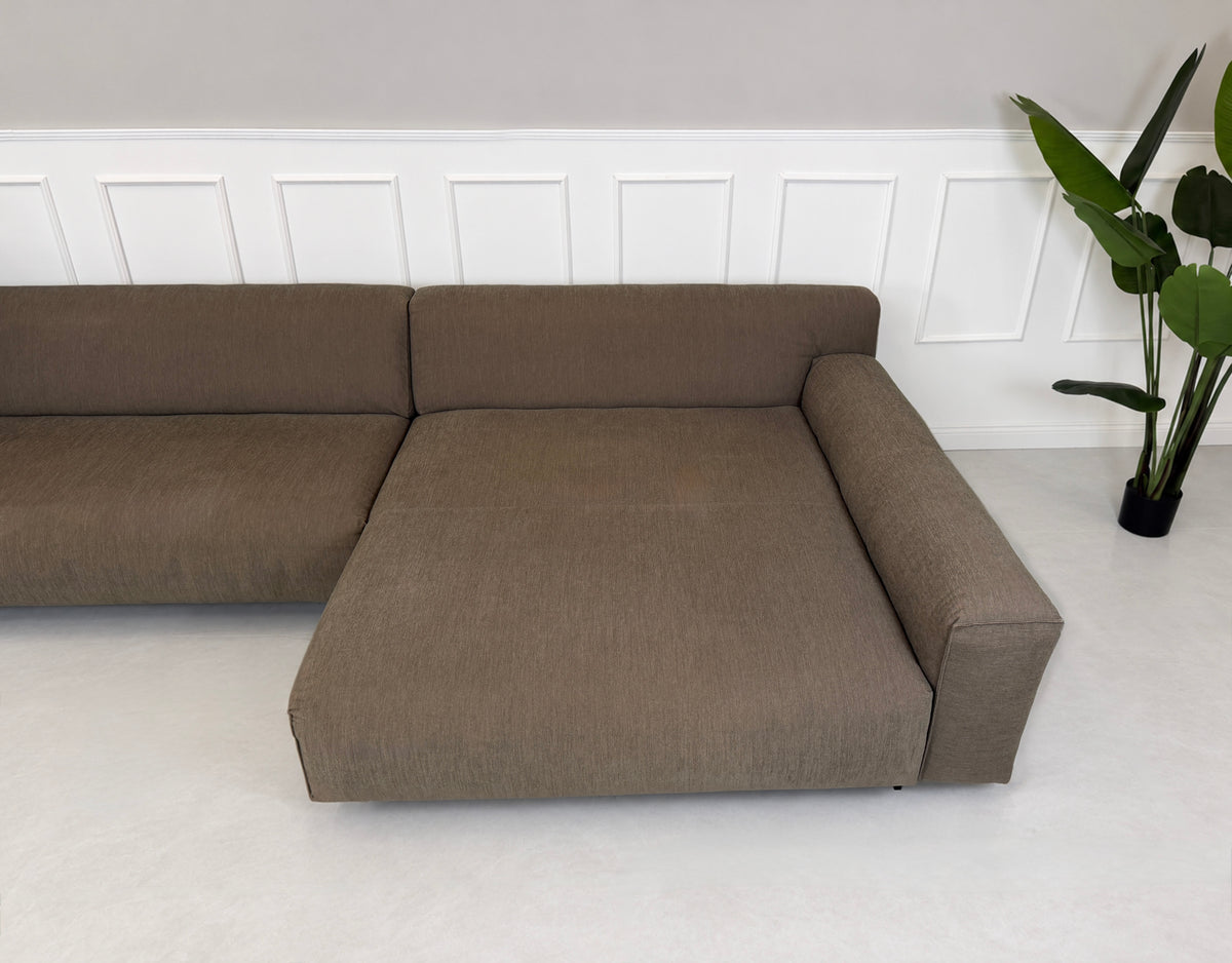 Gebrauchtes braunes Rolf Benz Grata Designer Stoff Ecksofa vor einer Wand, stilvoll und modern eingerichtet.