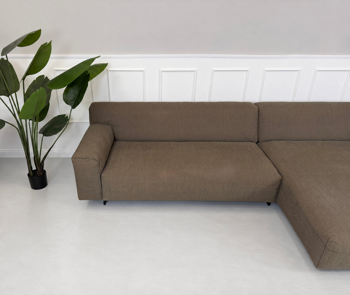 Gebrauchtes braunes Rolf Benz Grata Designer Stoff Ecksofa vor einer Wand, stilvoll und modern eingerichtet.