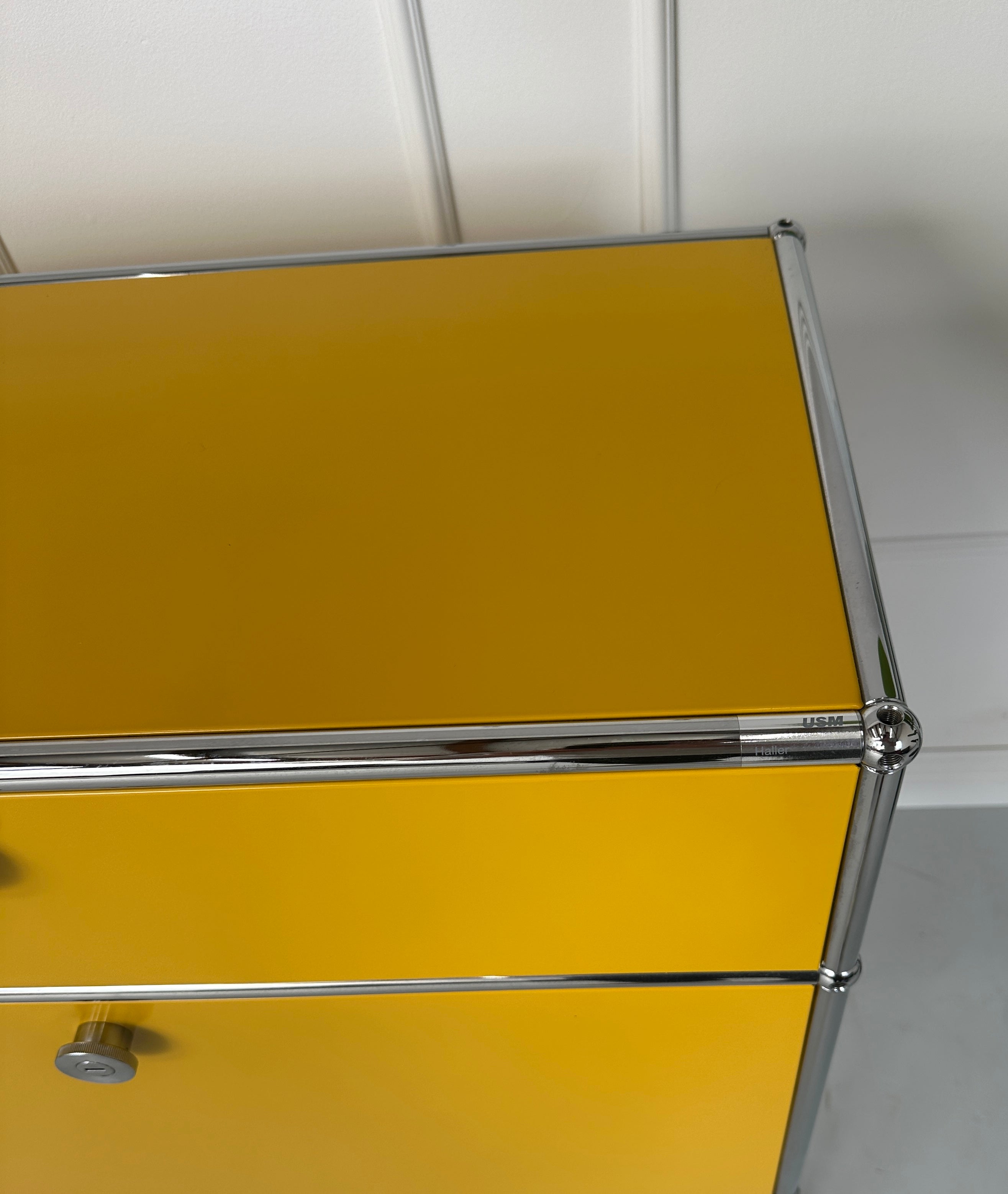 Gebrauchtes gelbes USM Haller Regal vor einer Wand, stilvoll und modern eingerichtet.