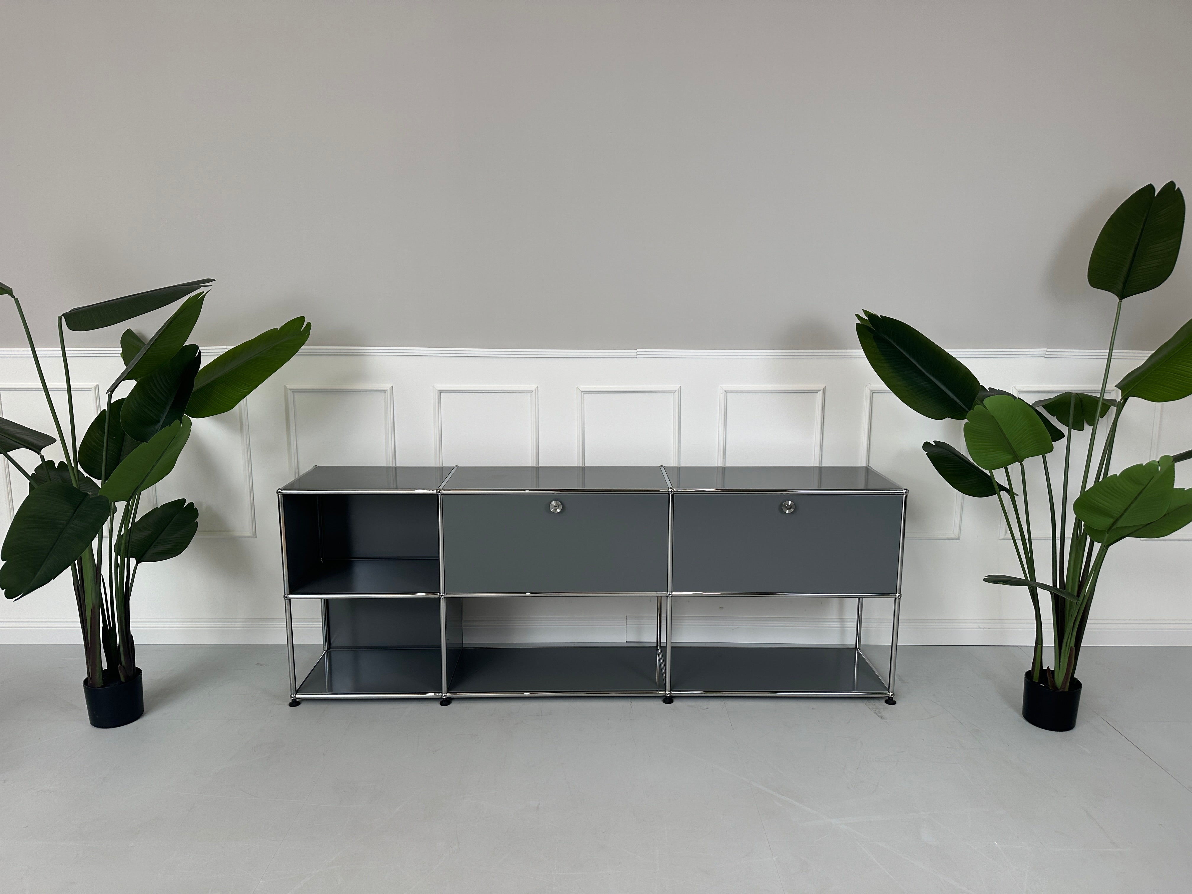 Gebrauchtes USM Haller Sideboard Regal in der Farbe Grau vor einer Wand, stilvoll und modern eingerichtet.
