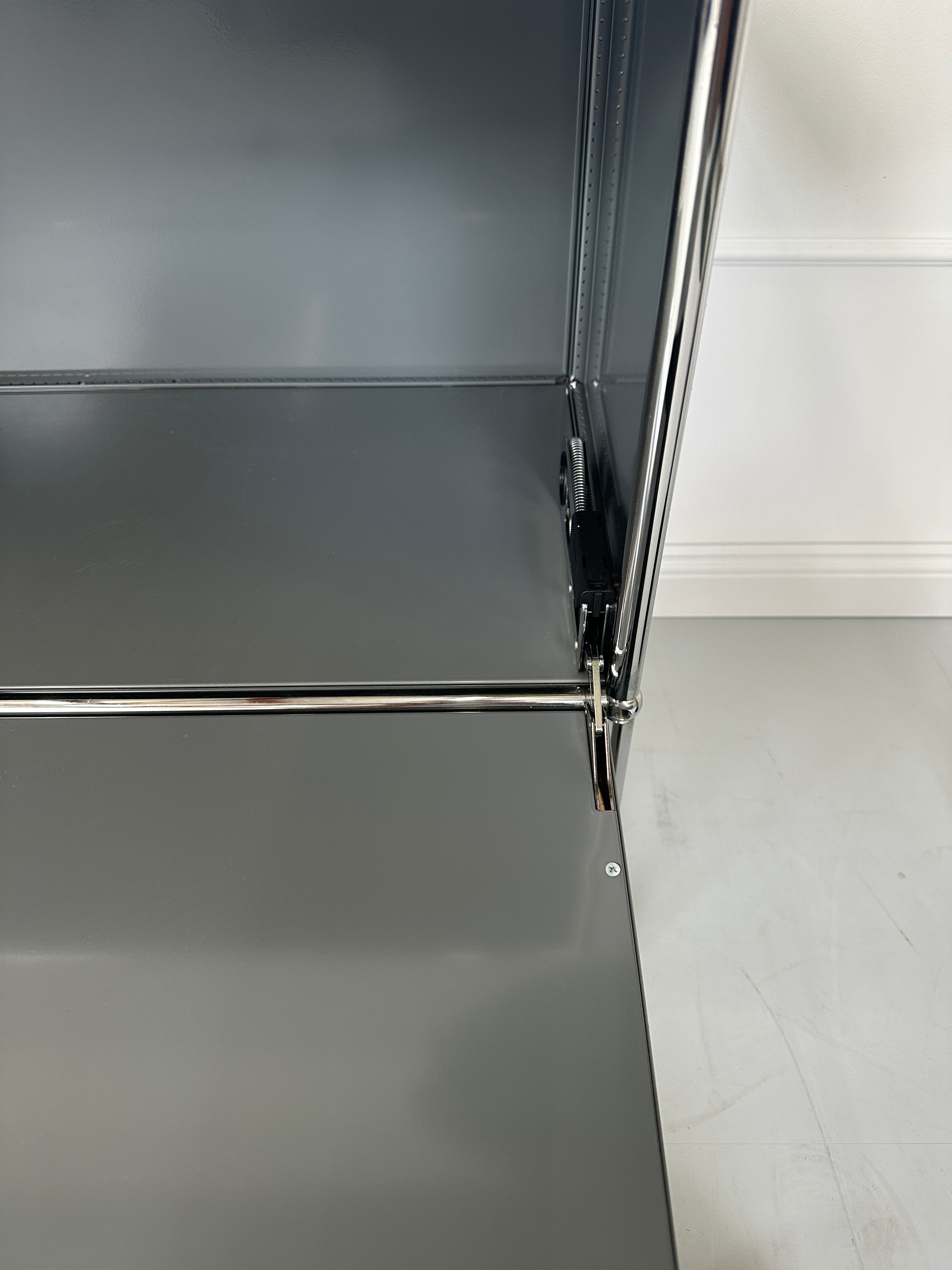 Gebrauchtes USM Haller Sideboard Regal in der Farbe Grau vor einer Wand, stilvoll und modern eingerichtet.