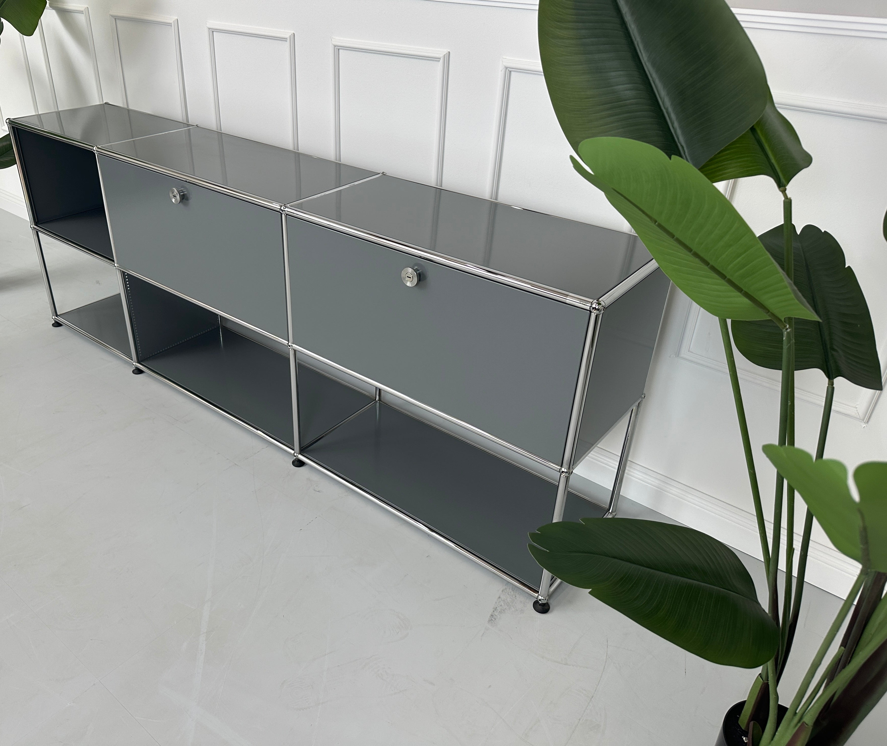 Gebrauchtes USM Haller Sideboard Regal in der Farbe Grau vor einer Wand, stilvoll und modern eingerichtet.