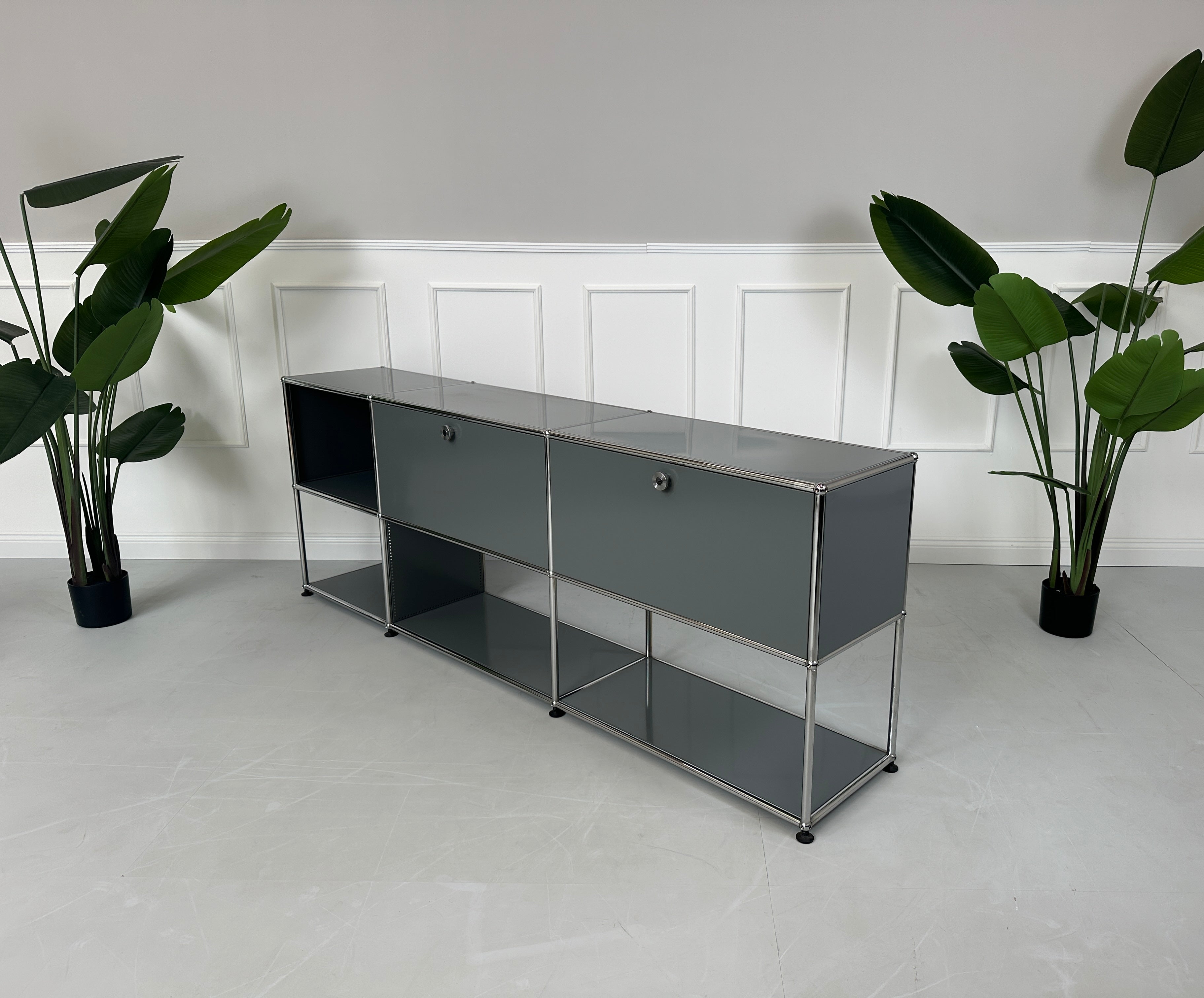Gebrauchtes USM Haller Sideboard Regal in der Farbe Grau vor einer Wand, stilvoll und modern eingerichtet.