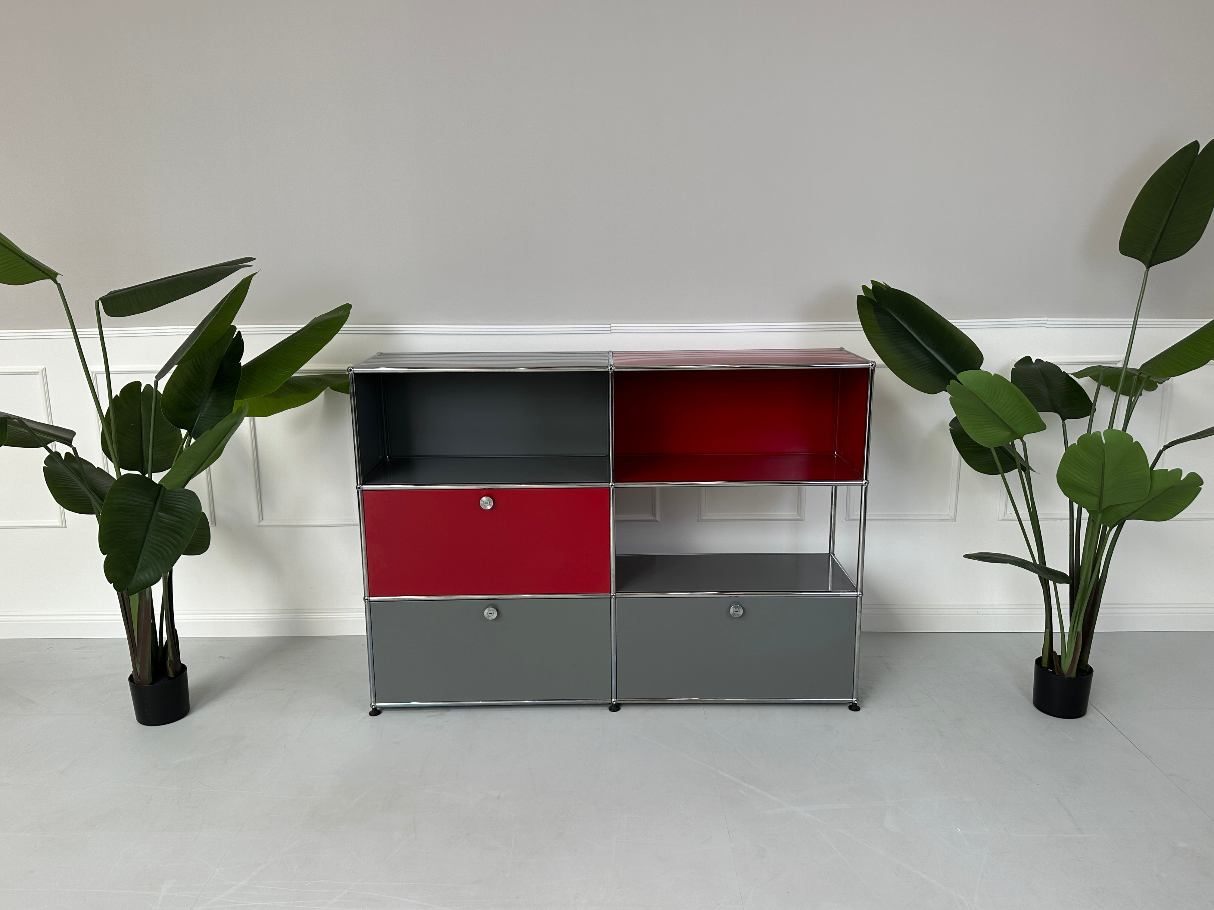 Gebrauchtes USM Haller Designer Regal in den Farben Rot und Grau vor einer Wand, stilvoll und modern eingerichtet.

