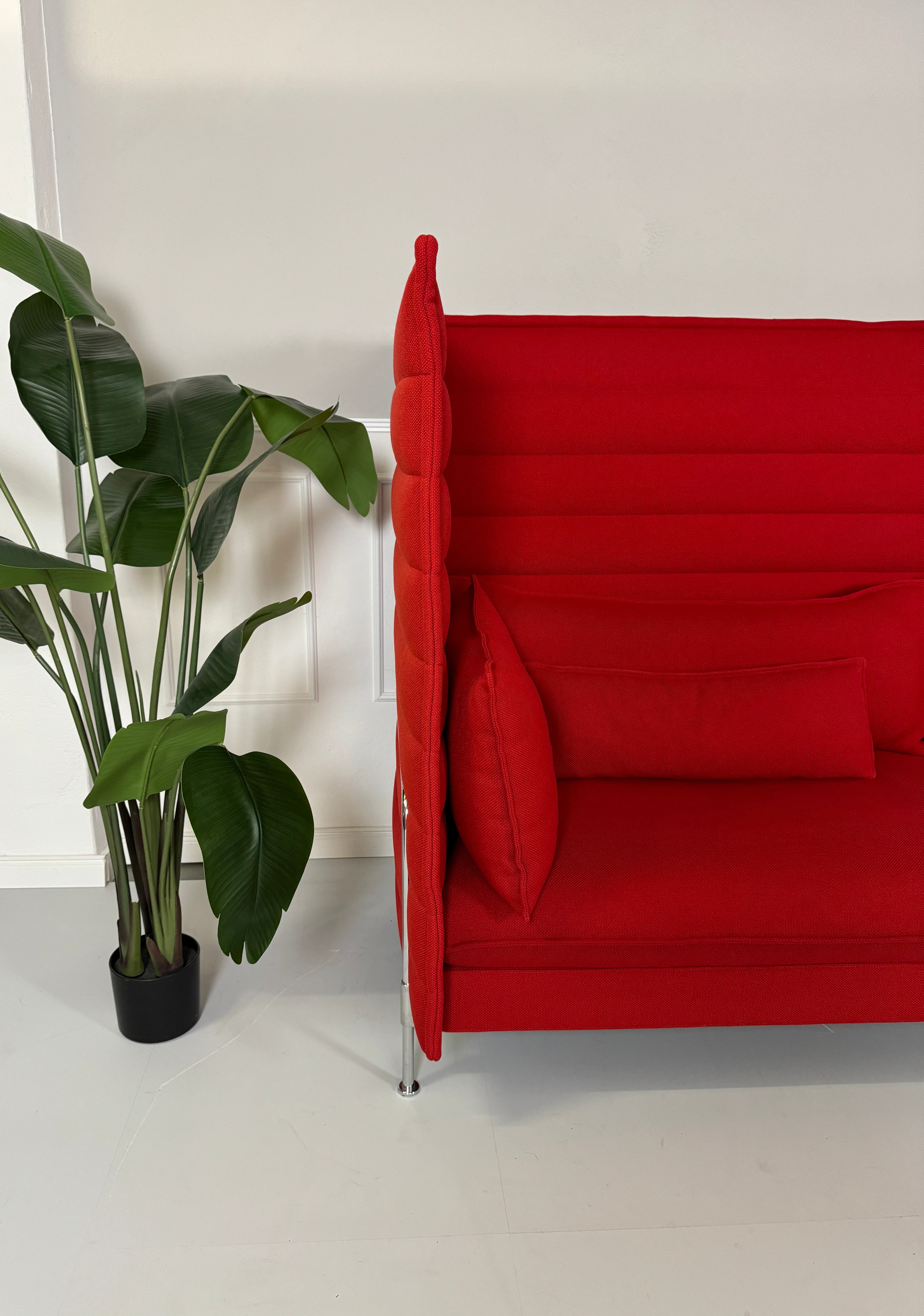 Gebrauchtes Vitra Alcove Sofa in der Farbe Rot vor einer Wand, stilvoll und modern eingerichtet.